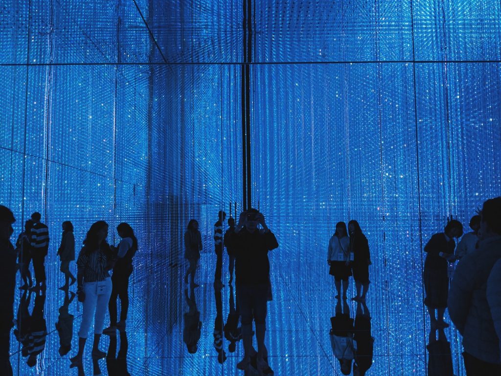 a group of people standing in front of a blue wall